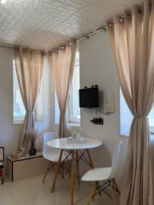 ヴァルナ・シティにあるDayanas Suiteのカーテン付きの部屋(テーブル、椅子付)