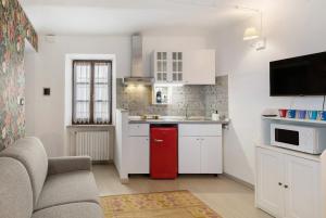 a small kitchen with white cabinets and a red refrigerator at Ca' Massimo Rivetti in Neive