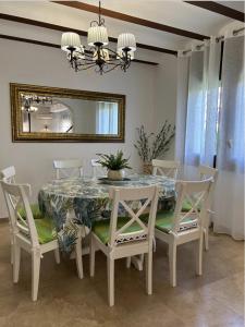 a dining room with a table and chairs and a mirror at Pino Alto Villa Jazmin in Miami Platja