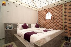 une chambre avec un grand lit dans une pièce dans l'établissement Desert Gold Resort Jaisalmer, à Jaisalmer