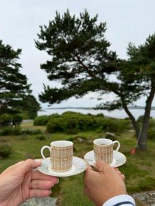 twee mensen die twee koffiekopjes en schoteltjes vasthouden bij Nilsen in Fredrikstad