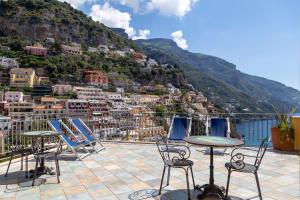 a patio with chairs and tables and a view of a city at Sea Soul Positano in Positano