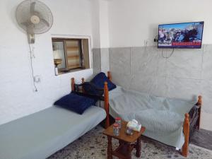 a room with two beds and a tv and a table at Sky2 in Jerash