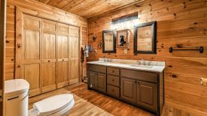 bagno con lavandino, servizi igienici e pareti in legno di Mountain Melody a Cherry Log Altre 42 foto