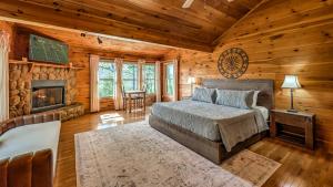 una camera con letto e camino in una baita di tronchi di Mountain Melody a Cherry Log