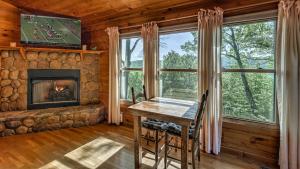 una sala da pranzo con camino in una baita di tronchi di Mountain Melody a Cherry Log