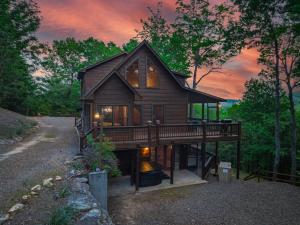 una casa con un ampio ponte nel bosco di Mountain Melody a Cherry Log