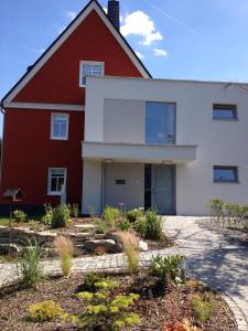 a red and white house with a driveway at Ferienhaus Bergwiese in Grünhain-Beierfeld