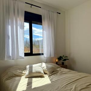 a bed in a bedroom with a window at Lo de Nieves - Casas con hermosa vista al Nevado y gran ubicación in Cachí