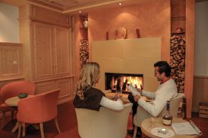 a man and a woman sitting in front of a fireplace at Berghotel zum Zirm in Collalbo +113 photos