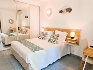 a bedroom with a large bed with a mirror at Hôtel Le Méditerranée in Hyères