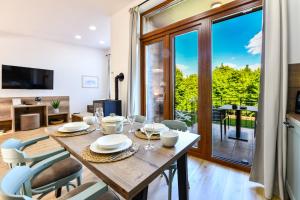 una sala da pranzo con tavolo e sedie e una grande finestra di House Bramado a Seliste Dreznicko