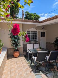 a patio with a table and chairs and flowers at Under Castle Walls cottage in Thessaloniki
