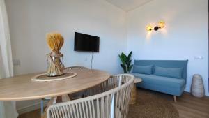 a living room with a table and a blue couch at Penthouse Studio Sea View in Alvor