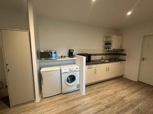 a kitchen with a washing machine and a washer at Neubau Monteurwohnung für 2-4 Gäste in Kiel in Kiel
