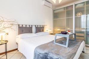 una camera da letto con un letto bianco e un tavolo di Cielo C18 by Houset a Monza