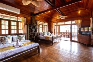 a large room with two beds and a tv at Luxury Villa Miramar Orchid House Samui in Amphoe Koh Samui