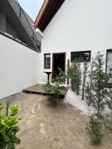 a white house with a porch and a patio at Refúgio na Natureza com hidro - Mariscal 09 in Bombinhas