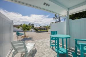 a patio with blue chairs and a table and chairs at 1 BR, Heated POOL, 1 Mile direct gulf access, GREAT Location, Dockage Apt B in Englewood