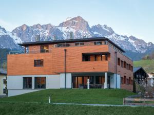 uma casa numa colina com montanhas ao fundo em Sport Chalet Maria Alm em Maria Alm am Steinernen Meer