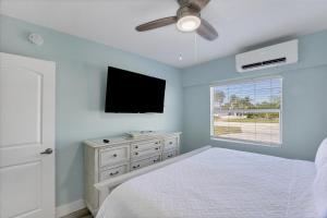 a bedroom with a bed and a flat screen tv at 1 BR, Heated POOL, 1 Mile direct gulf access, GREAT Location, Dockage Apt B in Englewood +12 photos