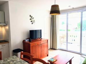 sala de estar con TV en un armario de madera en Appt T4 Résidence Le Cordouan 3 étoiles côté Piscine, en Soulac-sur-Mer