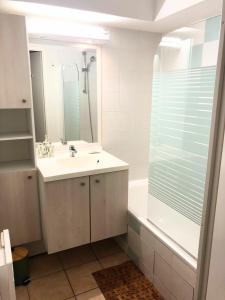Un baño con lavabo, ducha y espejo. en Appt T4 Résidence Le Cordouan 3 étoiles côté Piscine, en Soulac-sur-Mer