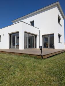 a white house with a large wooden deck at Magnifique maison proche des plages in Plouzané +11 photos