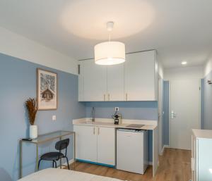 安纳马斯M109 Marquer Studio cozy proche du centre et de la gare的配有白色橱柜、桌子和椅子的厨房