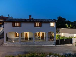 una casa bianca con una recinzione davanti di Ferienhaus mit Privatpool für 6 Personen ca 140 qm in Loborika, Istrien Südküste von Istrien a Loborika