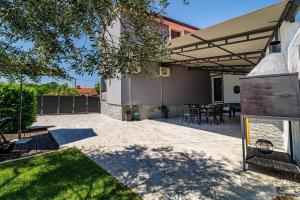 patio con tavolo e sedie sotto tenda di Ferienhaus mit Privatpool für 6 Personen ca 140 qm in Loborika, Istrien Südküste von Istrien a Loborika