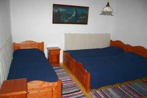 a bedroom with two beds and a picture on the wall at Anna Falusi Vendégház Sarud in Sarud