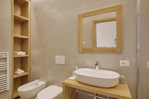 a bathroom with a sink and a mirror and a toilet at Hotel Le Mura in Lazise