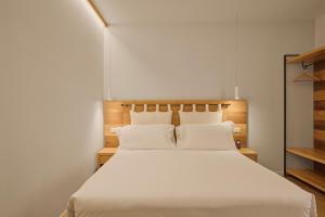 a bedroom with a large white bed with white sheets at Hotel Le Mura in Lazise