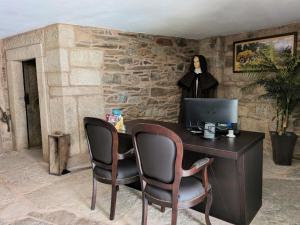 an office with a desk with a computer and two chairs at Casa do Poço in Miranda do Douro