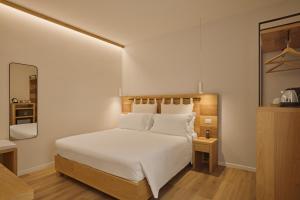 a bedroom with a white bed and a mirror at Hotel Le Mura in Lazise