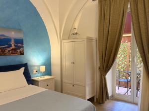 a bedroom with a bed and a door to a balcony at Chiaia Suites in Naples