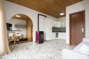 an open living room with a kitchen with white cabinets at Buena Vista in Germignaga +8 photos