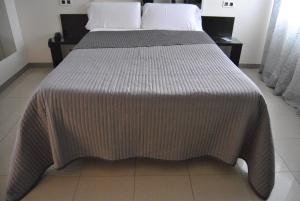 uma cama com um cobertor num quarto em Motel Cancun Oviedo em Llanera