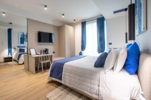 a bedroom with a bed with blue and white pillows at Poetica Verona in Verona