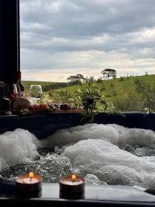 una vasca da bagno piena d'acqua con tre candele di Zlatibor Wild nest Rabbit Lux a Zlatibor