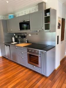 a kitchen with stainless steel appliances and wooden floors at Sea Front Olden in Olden