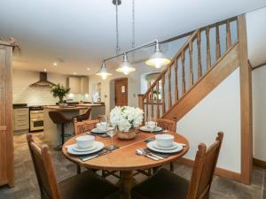 纽波特Graig Cottage的配有木桌的厨房和餐厅