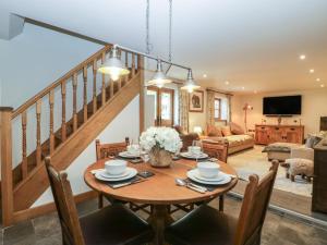 纽波特Graig Cottage的一间带桌子和楼梯的用餐室