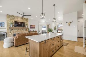 an open kitchen and living room with a stone fireplace at Rare Fall Dates Hot Tub & Game Room Dogs in Driggs