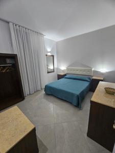 a bedroom with a bed with a blue bedspread at Alle Porte di San Vito 2 in San Vito lo Capo