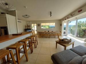 a kitchen and living room with a counter and chairs at Le Point Sublime – Villa de Charme à Vaison la Romaine in Vaison-la-Romaine