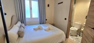 a bedroom with a white bed with two pillows at Das Carretas in Madrid +59 photos