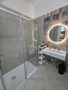 a bathroom with a shower with a sink and a mirror at Alle Porte di San Vito 2 in San Vito lo Capo