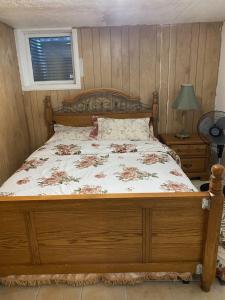 a bedroom with a wooden bed with a floral bedspread at Peace and Comfort 1-bedroom basement Apartment in Brampton